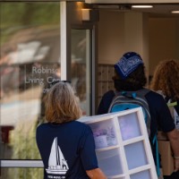 Women carries white dorm organizer into building